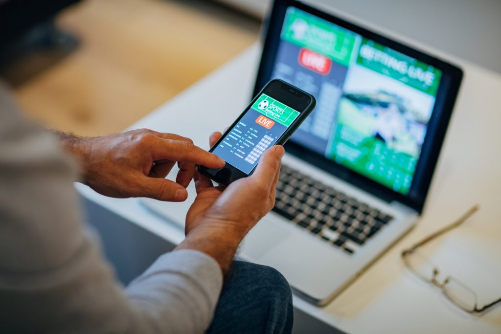 Guy Betting in an Online Casino using his Phone